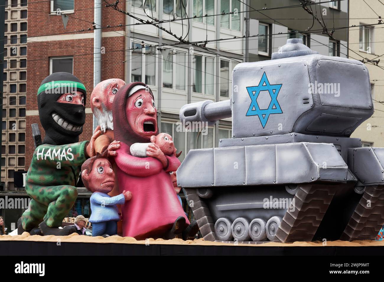 Il terrorista di Hamas si nasconde dietro i civili di fronte a un carro armato israeliano, figure di cartapesta, galleggiante satirico di Jacques Tilly, sfilata del lunedì delle rose Foto Stock