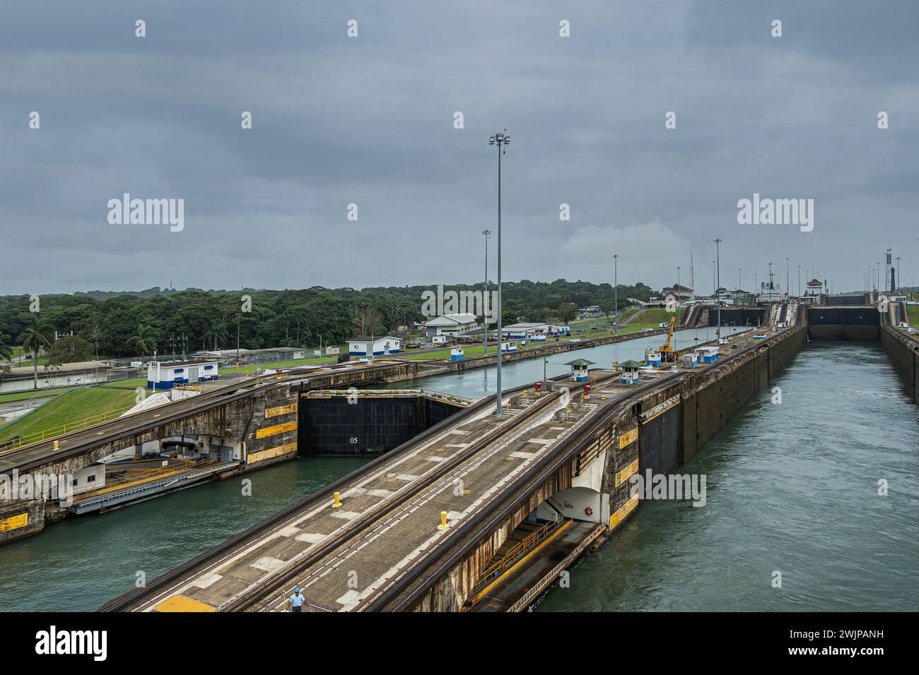 Canale di Panama, Panama - 24 luglio 2023: Raggiungere il livello dell'acqua dell'Atlantico dalle chiuse di Gatun sotto un paesaggio nuvoloso grigio-blu. Le banchine separano i due corsi d'acqua. G Foto Stock