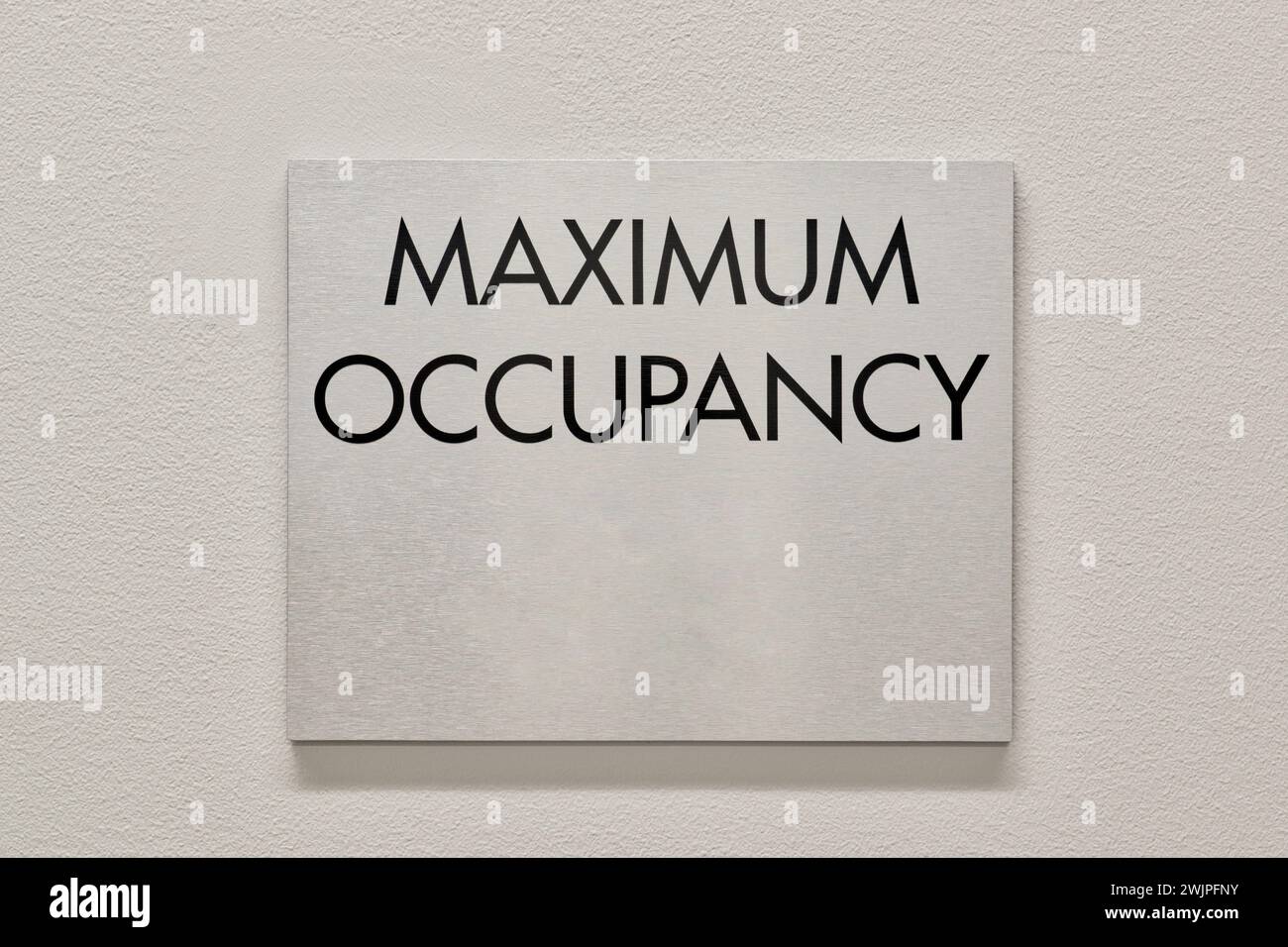 Cartello di occupazione massima su una parete interna bianca in un edificio commerciale. Un requisito NFPA Fire Marshal per proteggere gli edifici dal sovraffollamento. Foto Stock