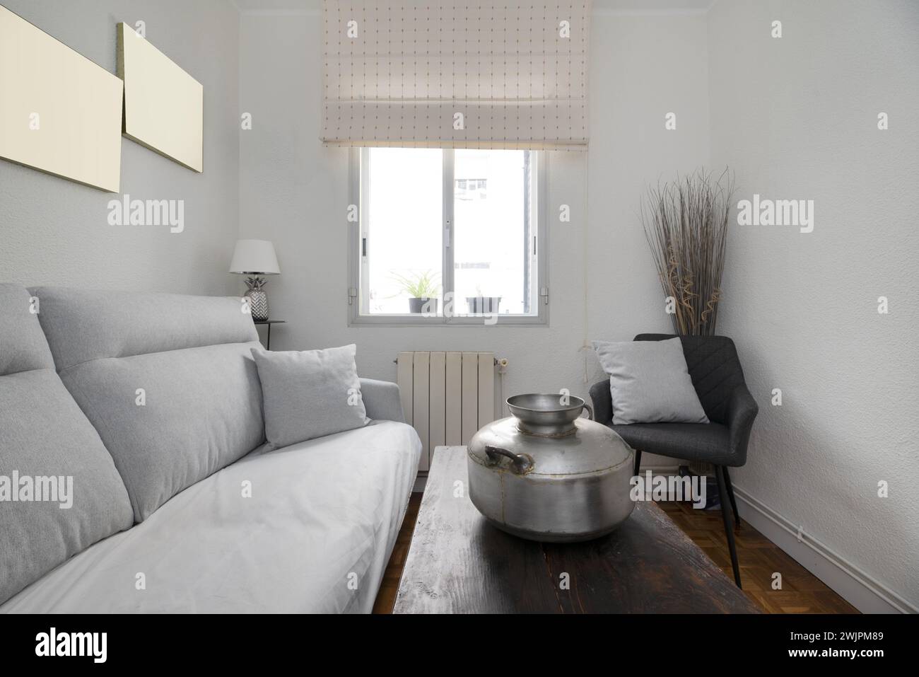 Piccolo soggiorno in una casa con mobili e accessori che combinano stile vintage e contemporaneo Foto Stock