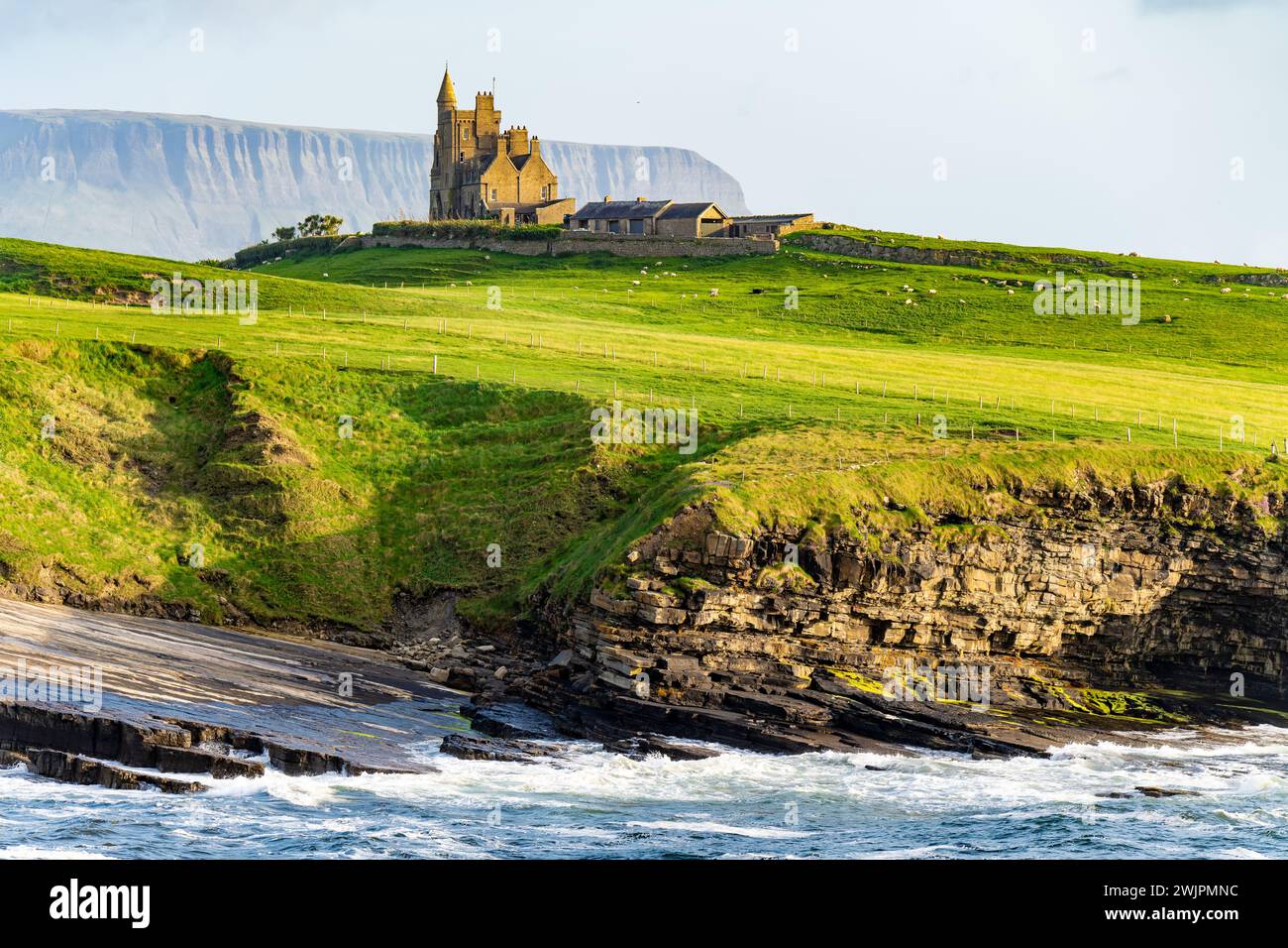 Famoso castello di Classiebawn nel pittoresco paesaggio di Mullaghmore Head. Spettacolare vista del tramonto con enormi onde che si infrangono a terra. Punto di firma di Wil Foto Stock