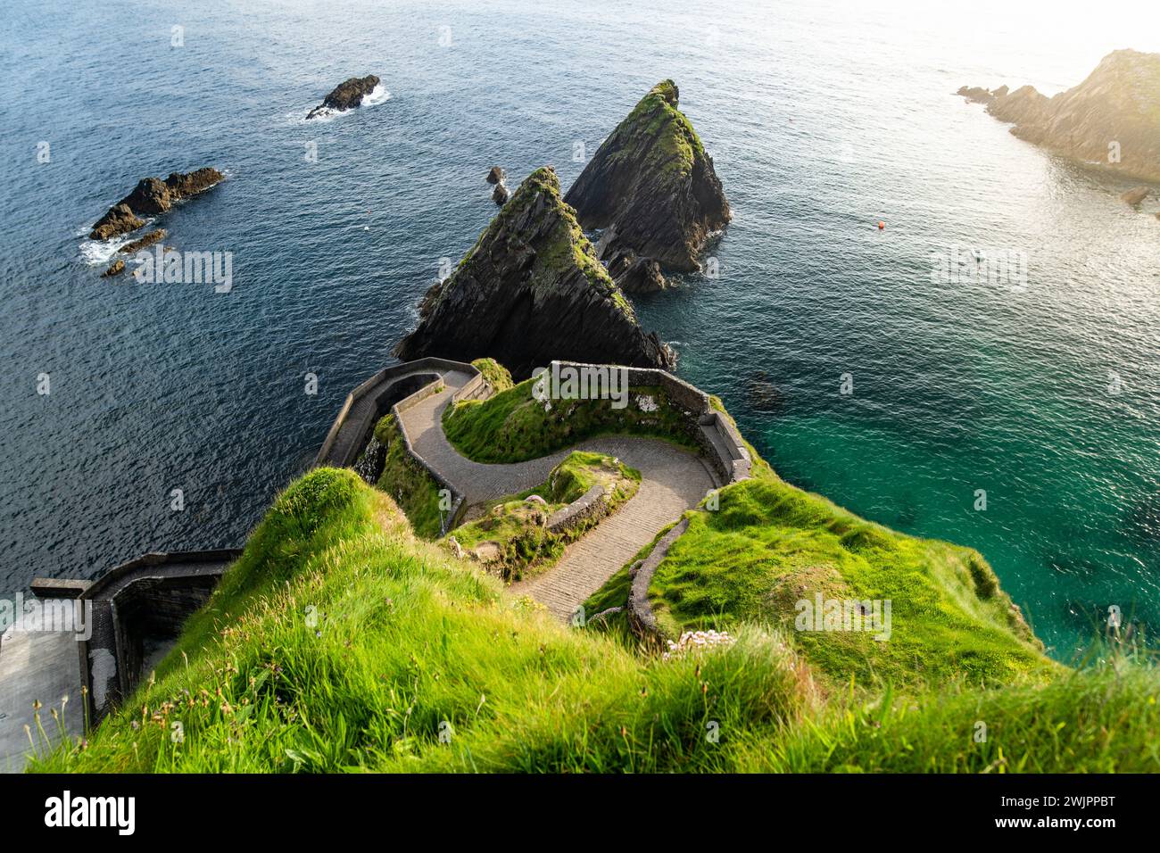 Molo di Dunquin o Dun Chaoin, Sheep Highway irlandese. Stretto sentiero che si snoda fino al molo, alla costa oceanica e alle scogliere. Famosa località iconica a Slea Foto Stock