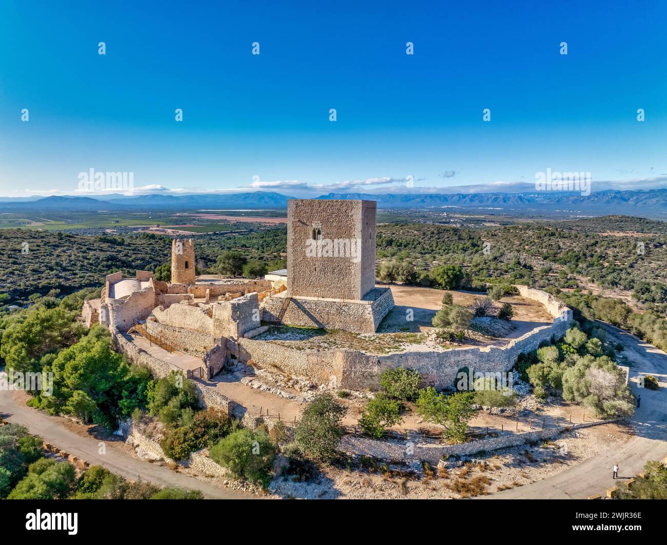 Veduta aerea del castello di Ulldecona, della cima della Serra grossa, dell'ex complesso fortificato di frontiera, dell'antica chiesa, dell'emblematica torre circolare e del mastio quadrato Foto Stock