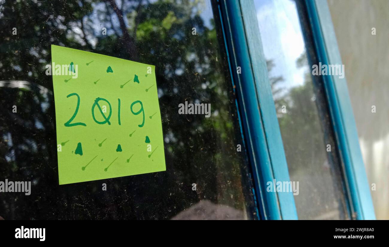 2019 foto di testo con carta verde su sfondo vetro della finestra della casa Foto Stock