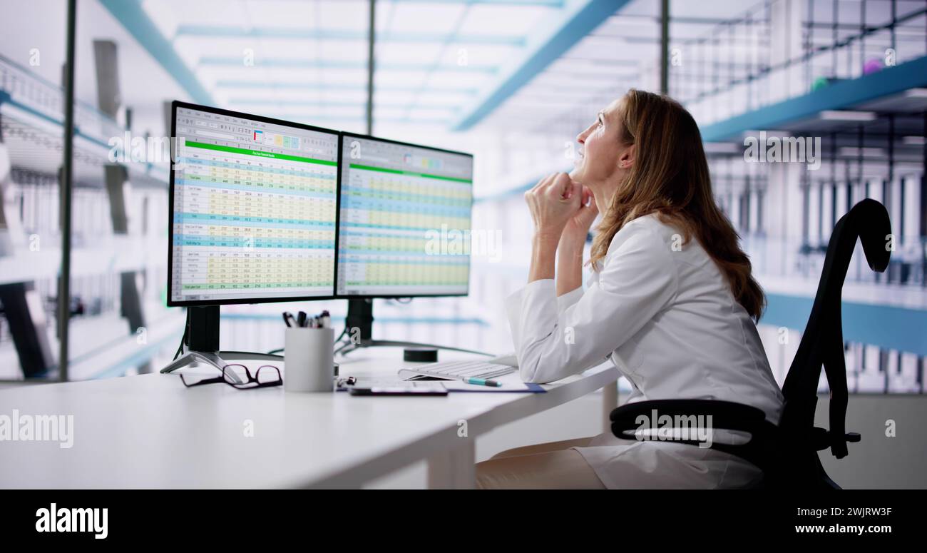 Medico infelice che fa codici foglio di calcolo sul computer Foto Stock