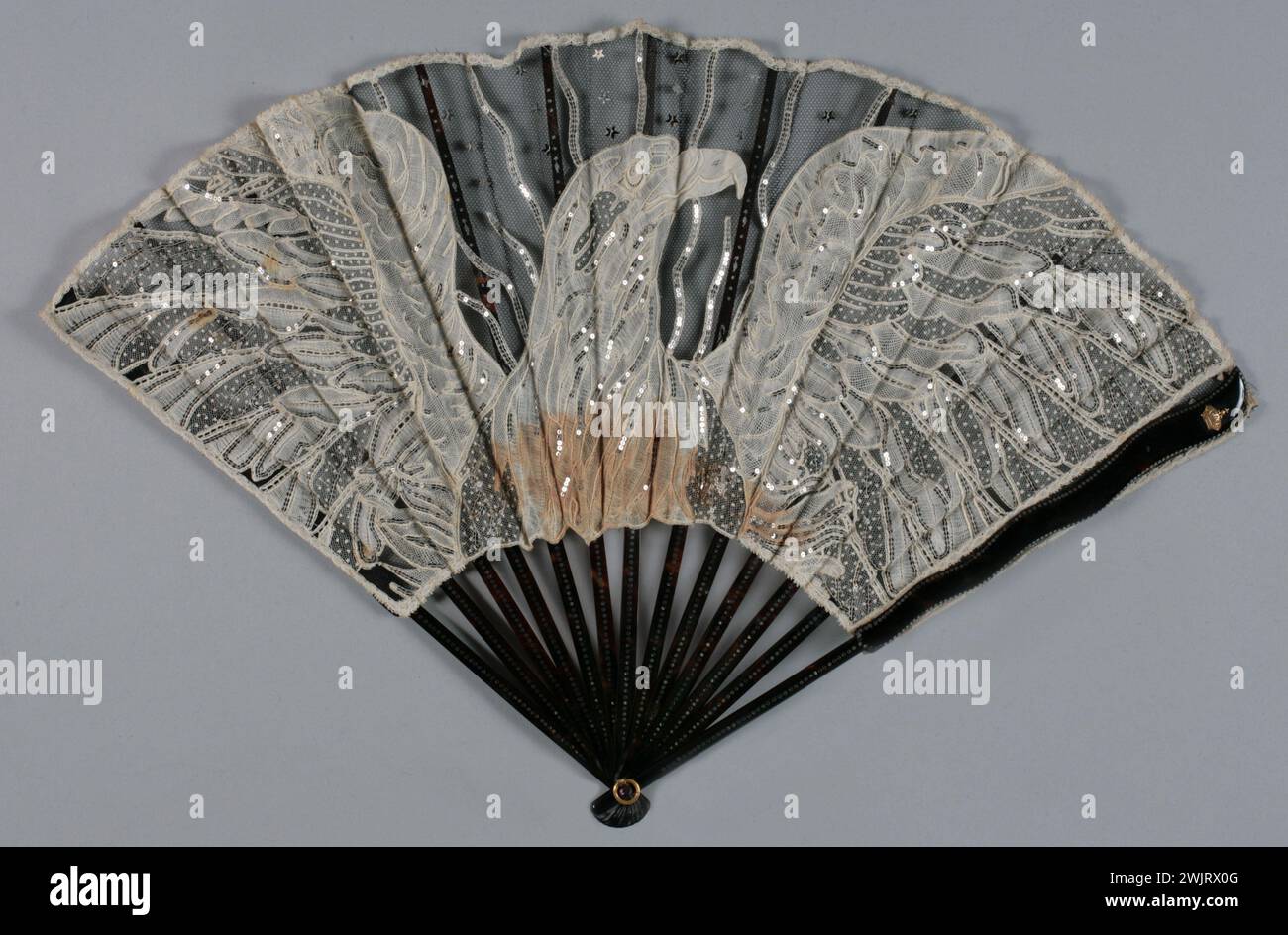 Raggio ripiegato, ornamento sul contrattacco: Corona. Foglia decorativa: Un'aquila con ali dispiegate. GAL1965.58.6 foglia di tulle nera con applicazione in pizzo bianco glitter, telaio in sottili lame in acciaio brunette marrone Foto Stock