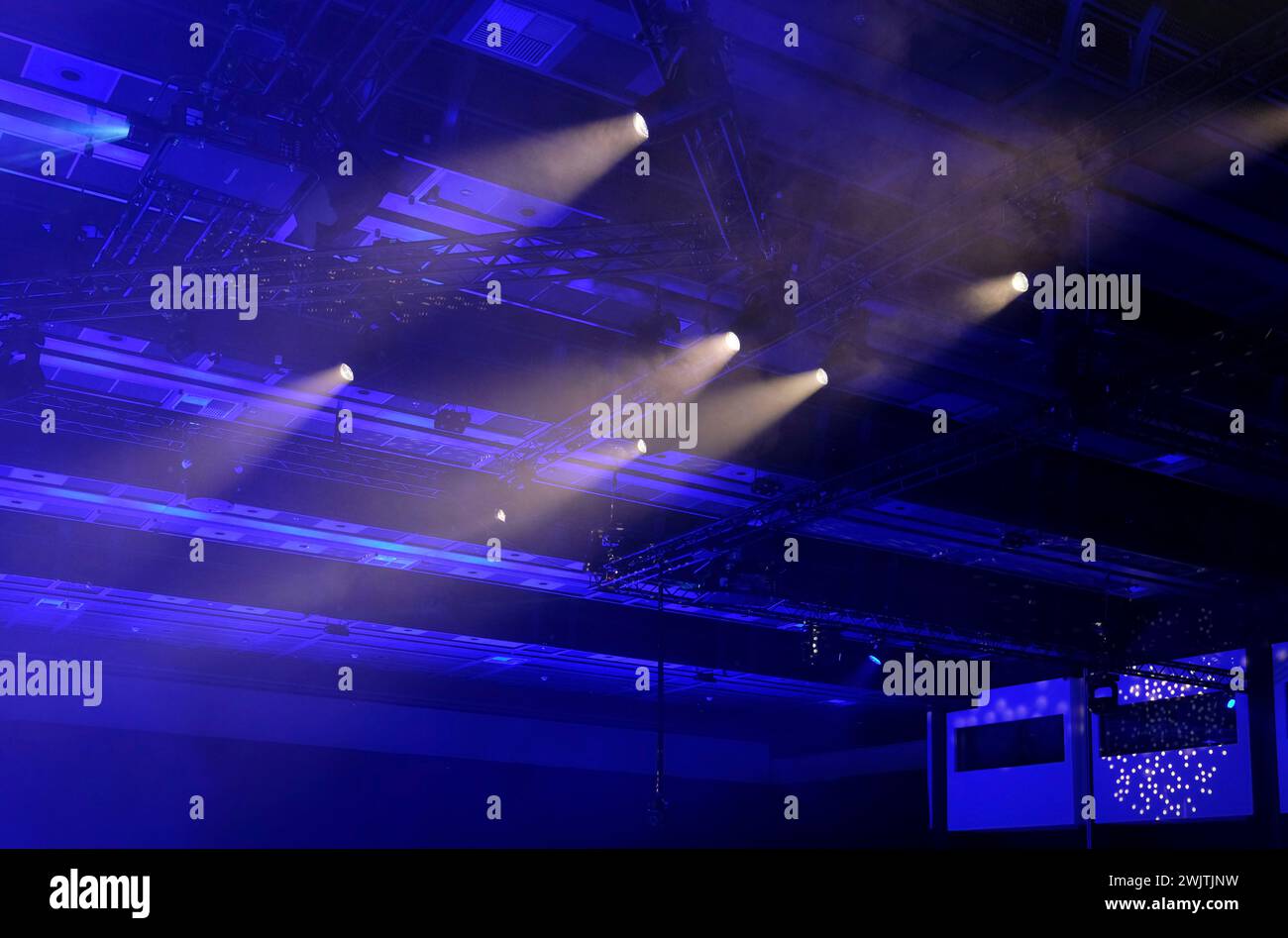 Luce ambiente e faretti in una stanza buia che splende dal soffitto Foto Stock