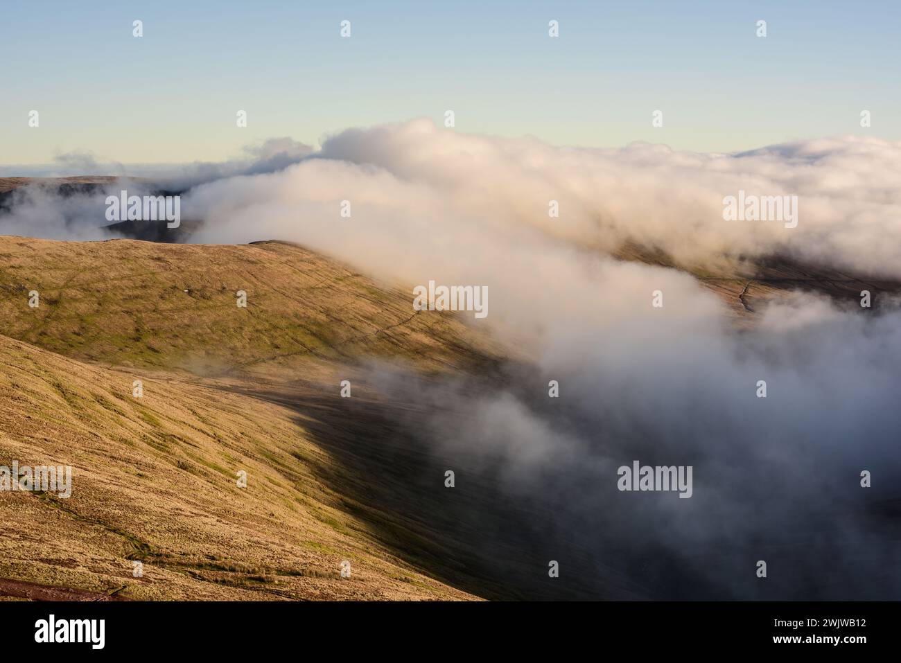 Vista dall'alto da Pen y fan, un punto più alto di Brecon Beacons, o Bannau Brycheiniog, Galles. Montagne coperte di nuvole. Foto Stock