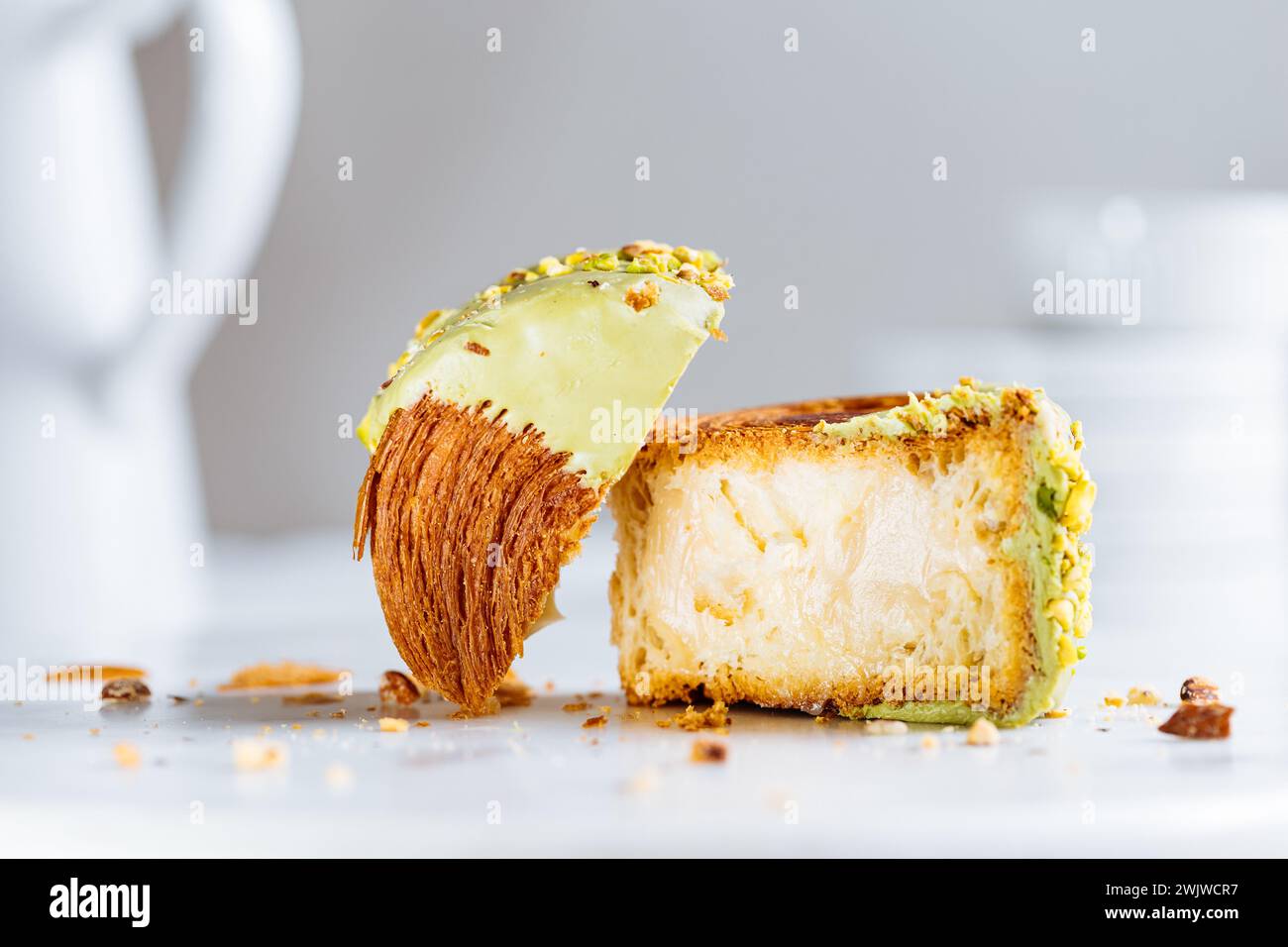 Croissant di fusione, pasticceria dolce Cromboloni. Dessert di New York. Pasta sfoglia rotonda ripiena di panna e glassata con cioccolato bianco al latte o pistacchio Foto Stock