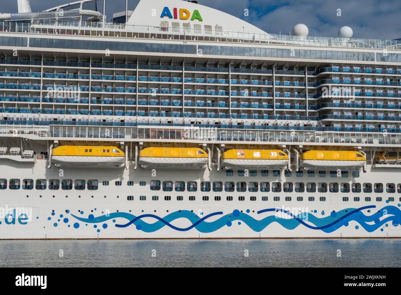 Foto lunga che mostra alcune cabine con balcone e scialuppe di salvataggio sulla nave da crociera AidaNova ormeggiata al terminal delle navi da crociera Ostseekai, Kiel, Germania. Foto Stock