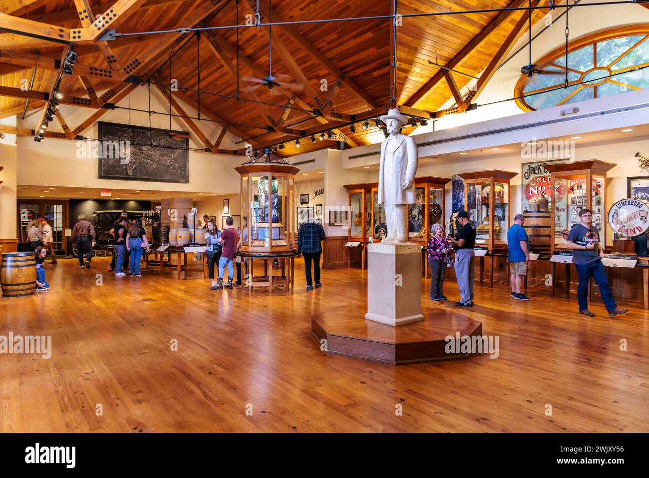 I visitatori osservano le esposizioni del museo intorno a una statua di Jack Daniel nel centro visitatori della distilleria Jack Daniel a Lynchburg, Tennessee Foto Stock