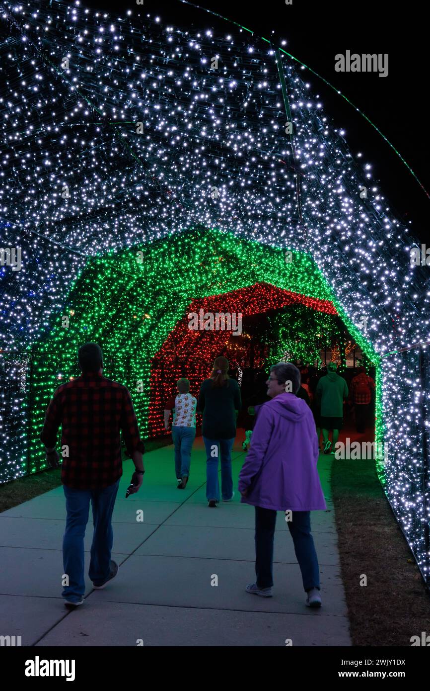 I visitatori camminano attraverso un tunnel di luci natalizie all'annuale Harbor Lights Winter Festival di Gulfport, Mississippi Foto Stock