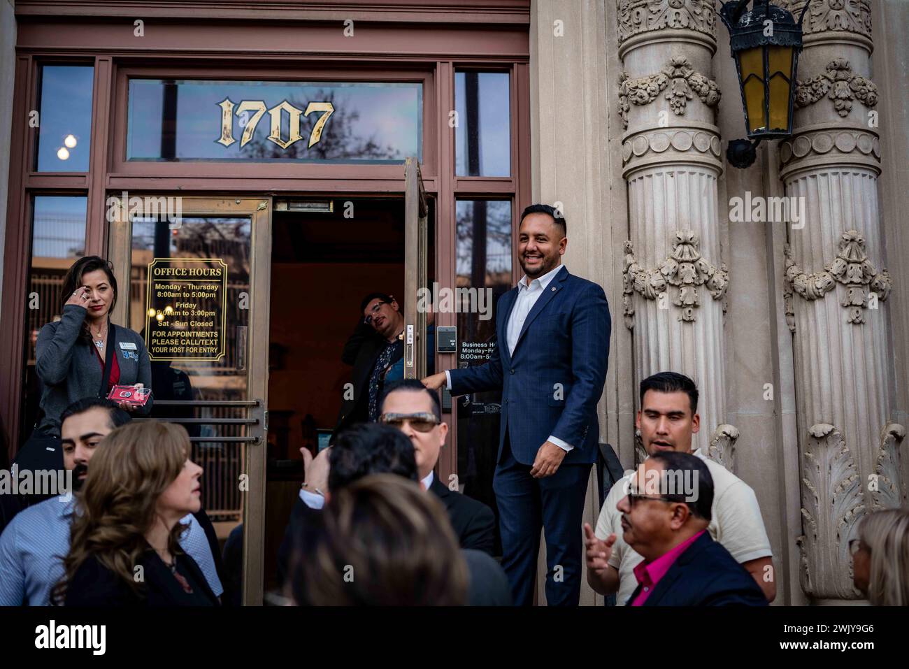 Bakersfield, California, Stati Uniti. 16 febbraio 2024. Il vice sindaco Andrae Gonzalez tiene aperta la porta a cittadini, dignitari e personale della United Way della California centro-orientale appena coniata il 16 febbraio 2024, nel centro di Bakersfield, California. L'organizzazione è precedentemente nota come United Way of Kern. I funzionari hanno dichiarato che l'adozione del nuovo nome segna una pietra miliare significativa nel "viaggio di impatto e crescita" della United Way Eastern California. La transizione iniziò nel novembre 2023, evolvendo dall'ex identità di United Way of Kern County all'attuale United Way of Foto Stock