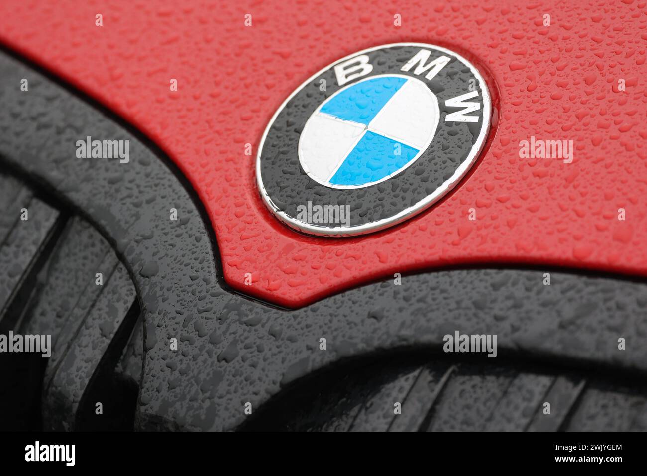 BMW Logo auf einem roten BMW Fahrzeug, Motorhaube. Auf dem lack und Logo sind Wassertropfen. BMW AM 17.02.2024 a Siegen/Deutschland. *** Logo BMW su un veicolo BMW rosso, cappuccio ci sono gocce d'acqua sulla vernice e logo BMW il 17 02 2024 a Siegen Germania Foto Stock