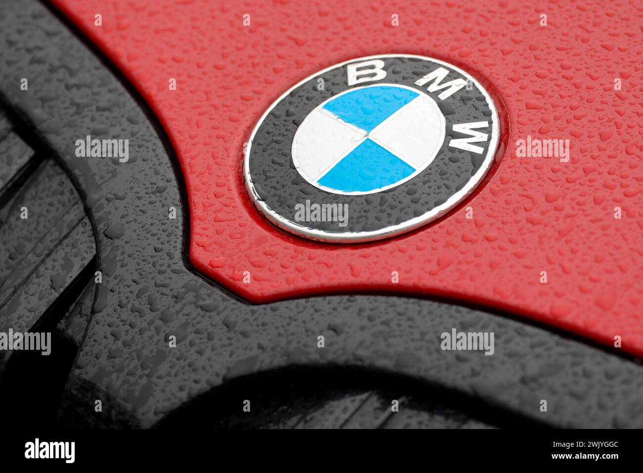 BMW Logo auf einem roten BMW Fahrzeug, Motorhaube. Auf dem lack und Logo sind Wassertropfen. BMW AM 17.02.2024 a Siegen/Deutschland. *** Logo BMW su un veicolo BMW rosso, cappuccio ci sono gocce d'acqua sulla vernice e logo BMW il 17 02 2024 a Siegen Germania Foto Stock