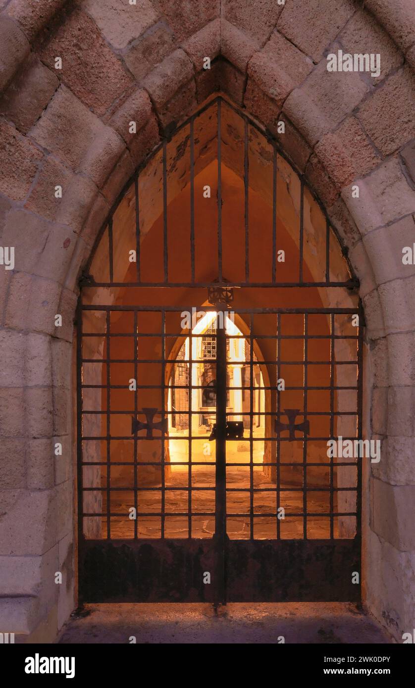 Cancello con barre di ferro in una fortezza medievale alle prime ore del mattino. Rodi. Grecia. Foto Stock