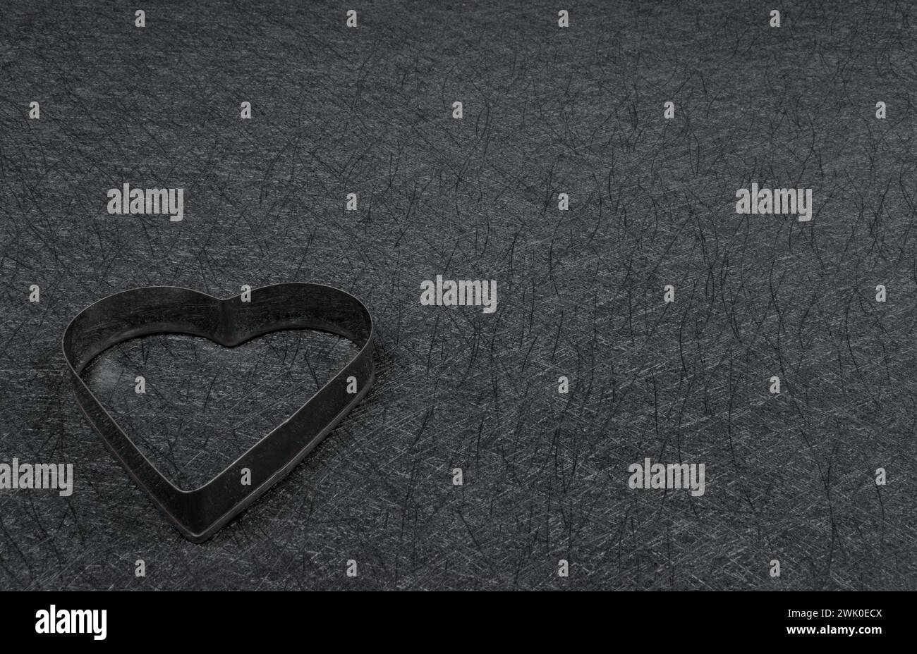 Telaio con cuore in acciaio su sfondo nero. Ottimo spazio per le copie. Foto Stock