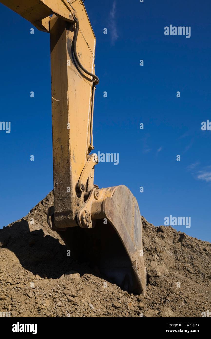 Primo piano della pala meccanica su una terna che raccoglie terreno. Foto Stock