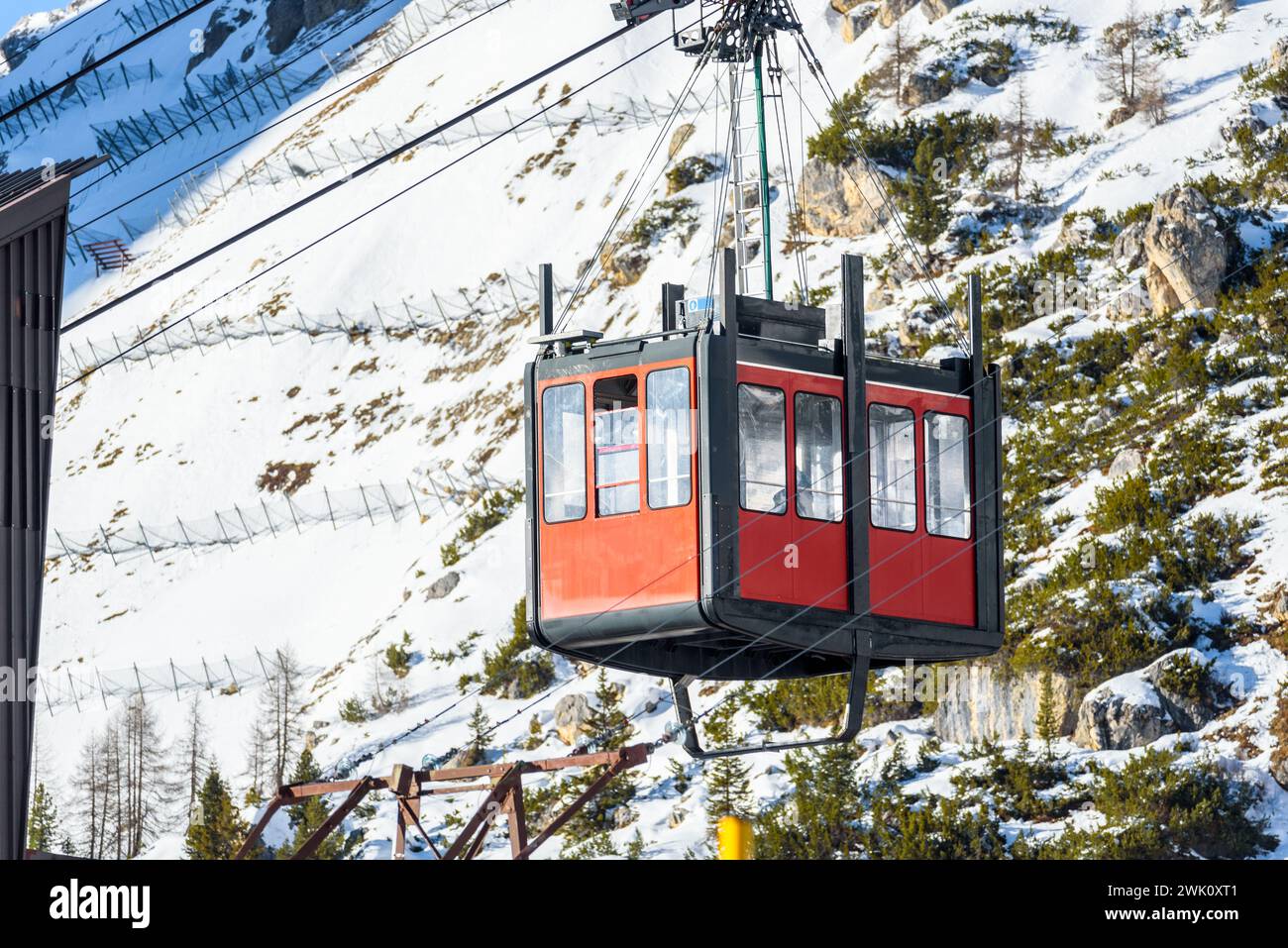 Dettaglio di una cabina della funivia aerea passeggeri che si avvicina alla stazione inferiore delle Alpi in una soleggiata giornata invernale Foto Stock