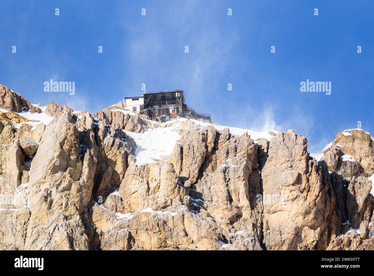 Stazione della funivia sulla cima di una montagna rocciosa innevata in una ventosa giornata invernale Foto Stock