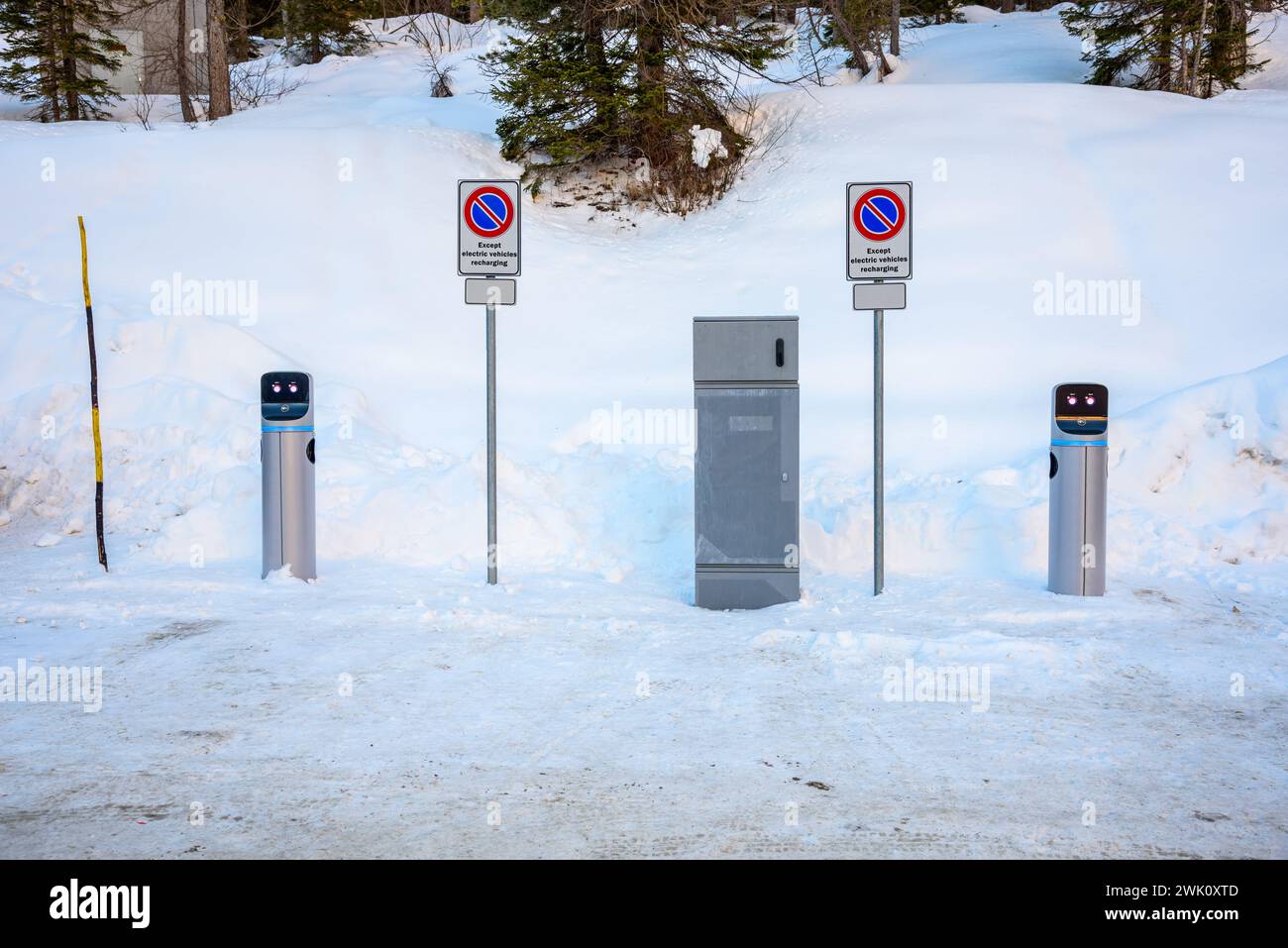 Stazione di ricarica per veicoli elettrici in un parcheggio coperto di neve in una stazione sciistica sulle Alpi in inverno Foto Stock