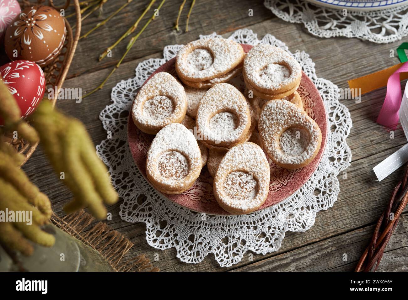 Biscotti al Linzer fatti in casa a forma di uova con decorazioni pasquali su un tavolo Foto Stock