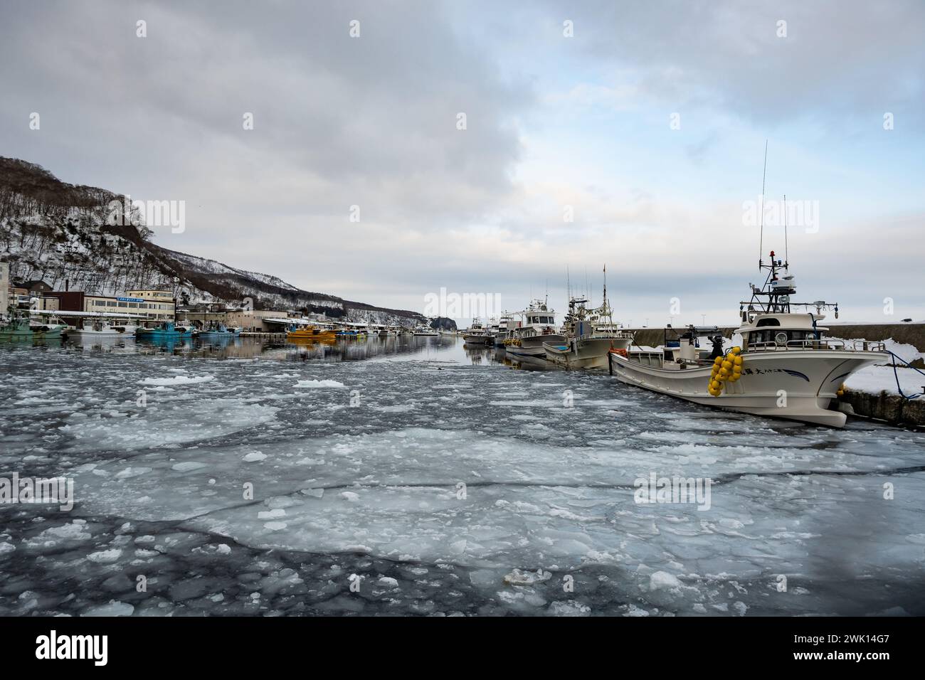 Barche da pesca in un porto ghiacciato. Rausu, Hokkaido, Giappone. Foto Stock