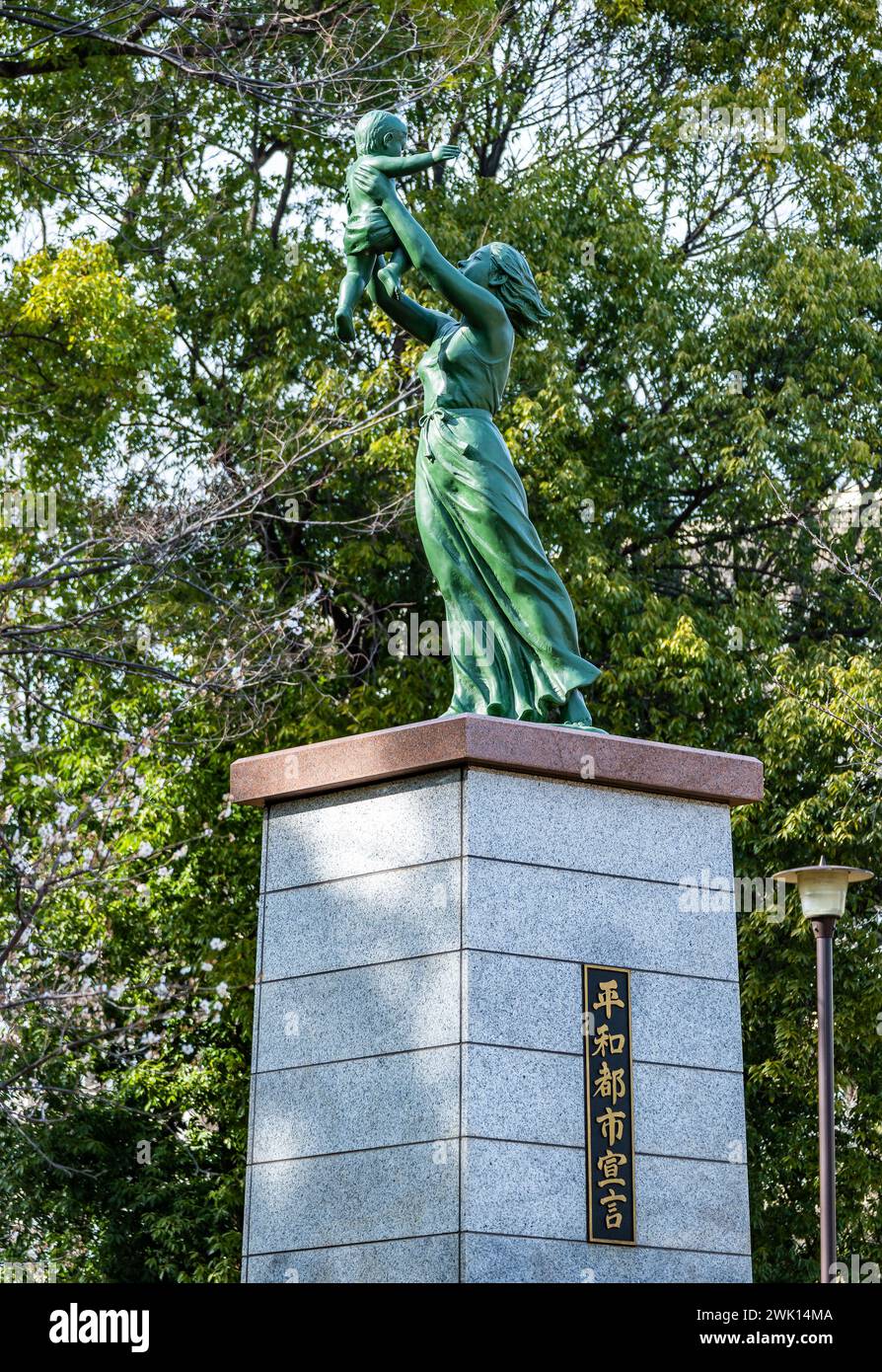 Statua di una madre che tiene in braccio un bambino in un parco locale, simbolo del desiderio di pace. Tokyo, Giappone. Foto Stock