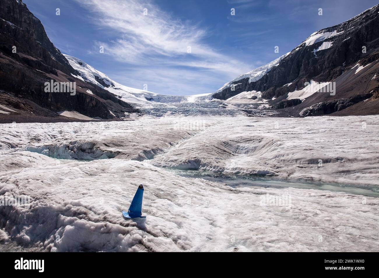 Un flusso d'acqua scorre al largo del ghiacciaio Athabasca in estate. La cascata di ghiaccio della calotta glaciale Columbia è sullo sfondo. Foto Stock