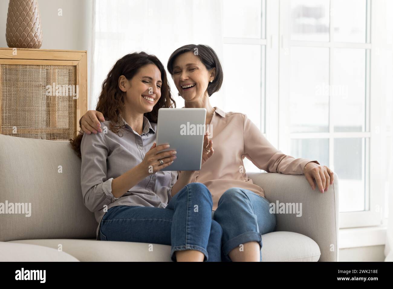 Famiglia multigenerazionale seduto sul divano utilizzando un moderno tablet digitale Foto Stock
