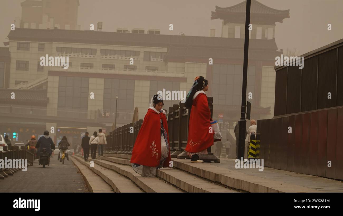 XI'AN, CINA - 18 FEBBRAIO 2024 - i pedoni camminano su una strada durante il tempo polveroso a Xi'an, provincia di Shaanxi, Cina, 18 febbraio 2024. E' unde Foto Stock