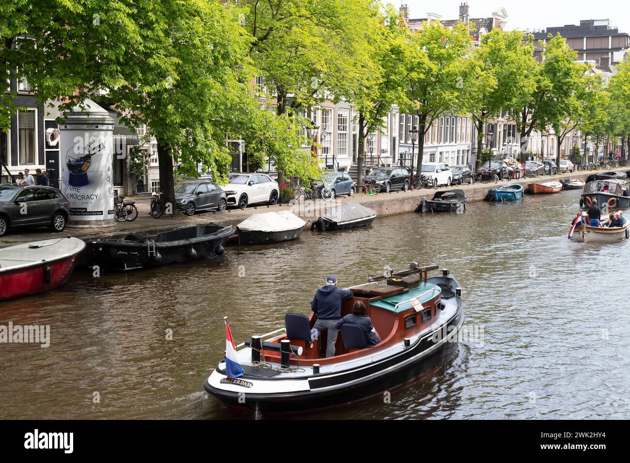 Naviga con una piccola barca attraverso i canali di Amsterdam. Foto Stock
