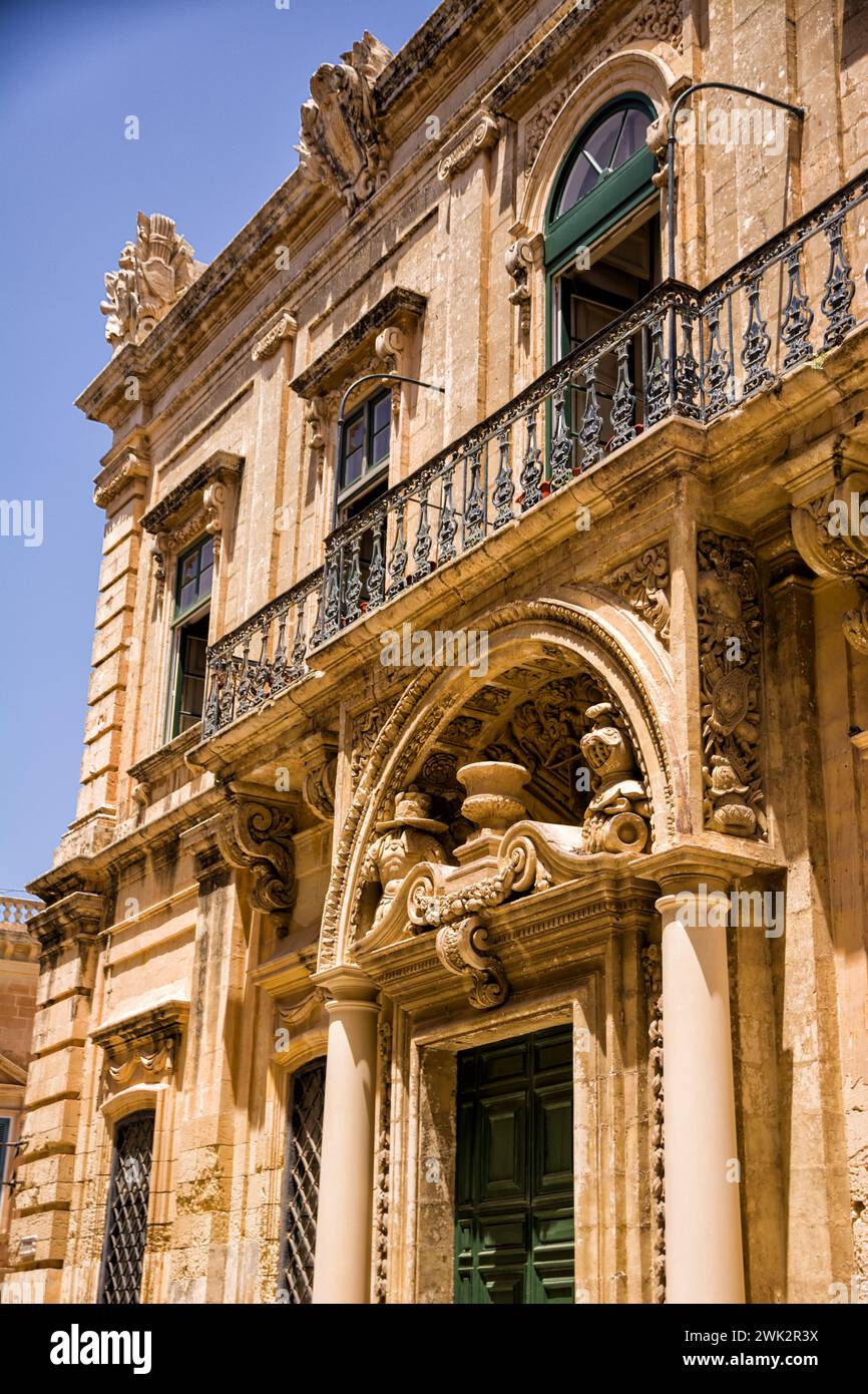 Facciata di un edificio, porta e balconi con struttura lavorata nel centro di Mdina (Malta) Foto Stock