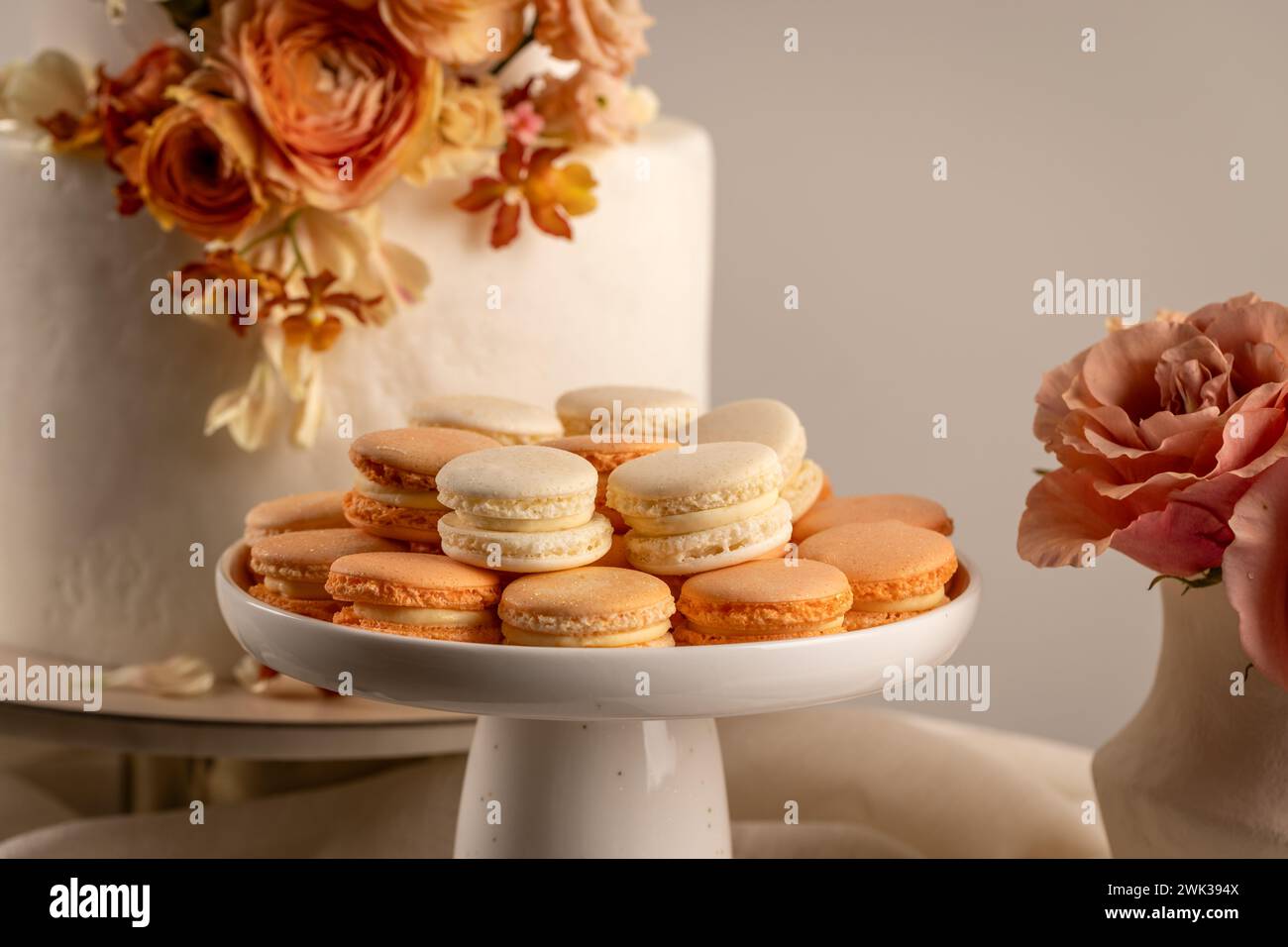 Macaron francesi in tavola da dessert. Gustosi biscotti sandwich colorati con pesca dolce Foto Stock