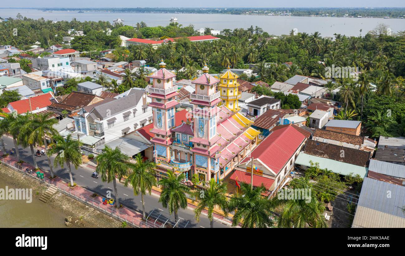 Sa Đéc, Vietnam. 18 febbraio 2024: Veduta aerea di un tempio di Cao Đài, dove vengono praticate le cerimonie e le preghiere dei seguaci del Caodaismo. Questa religione sincretica monoteistica vietnamita, rivendicando 5 milioni di credenti in tutto il mondo, ha celebrato la grande cerimonia dell'essere Supremo nell'anno del Drago 2024, come ogni anno l'8/9 del primo mese lunare. Questo è uno dei rituali più importanti della Chiesa di Cao dai. Sulla base delle pratiche occulte del Taoismo, questo culto celebrerà il suo 100 ° anniversario ufficiale nel 2026. Crediti: Kevin Izorce/Alamy Live News Foto Stock