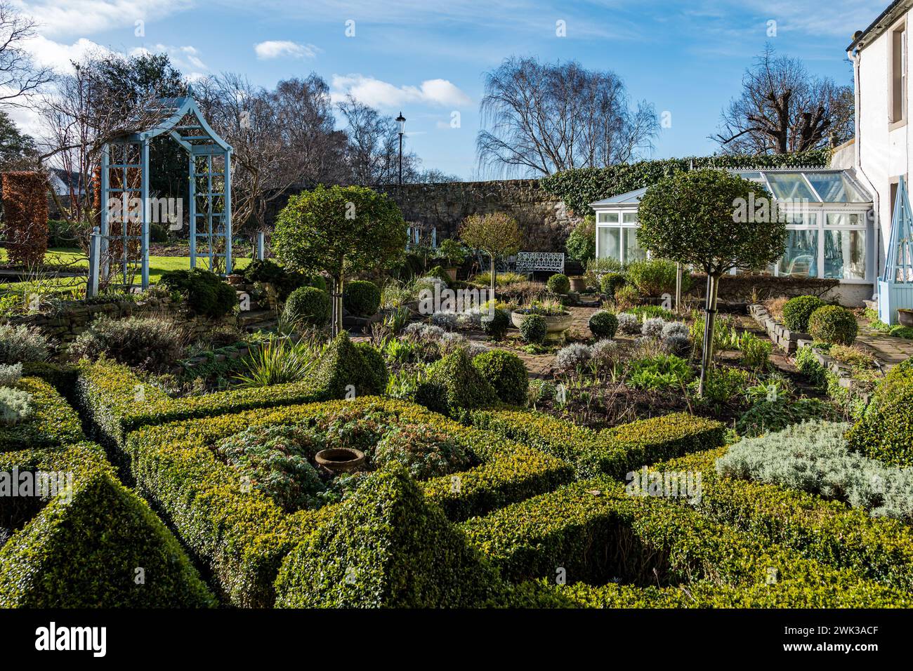 Shepherd House Garden, Inveresk, East Lothian, Scozia, Regno Unito 18 febbraio 2024. Scotland's Garden Scheme Snowdrop Weekend: Il giardino è aperto al pubblico con donazioni d'ingresso destinate a beneficenza. Nella foto: Il giardino formale ha molte caratteristiche ornamentali. Crediti: Sally Anderson/Alamy Live News Foto Stock