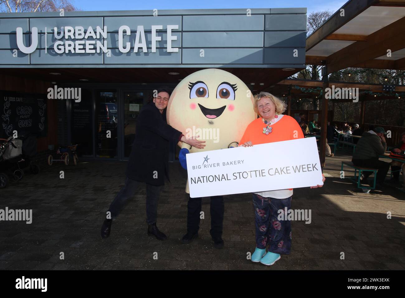 National Stottie Cake Week con la mascotte di Big River Bakery Scotty the Stottie che partecipa all'Urban Green Exhibition Park Café. La Big River Bakery, situata nel cuore di Shieldfield, Newcastle, ha recentemente annunciato una prima edizione culinaria: La National Stottie Cake Week. Una stottie è un tipo di pane rotondo, piatto e cotto sul fondo di un forno, che si traduce in una consistenza scrumptibilmente morbida ma gommosa. Prende il nome dalla parola Geordie «stot» – che significa «rimbalzare» – poiché tradizionalmente una stottie perfettamente cotta dovrebbe rimbalzare quando viene lasciata cadere. Newcastle upon Tyne, 18 febbraio 2024, credito: DEWAlamy Foto Stock