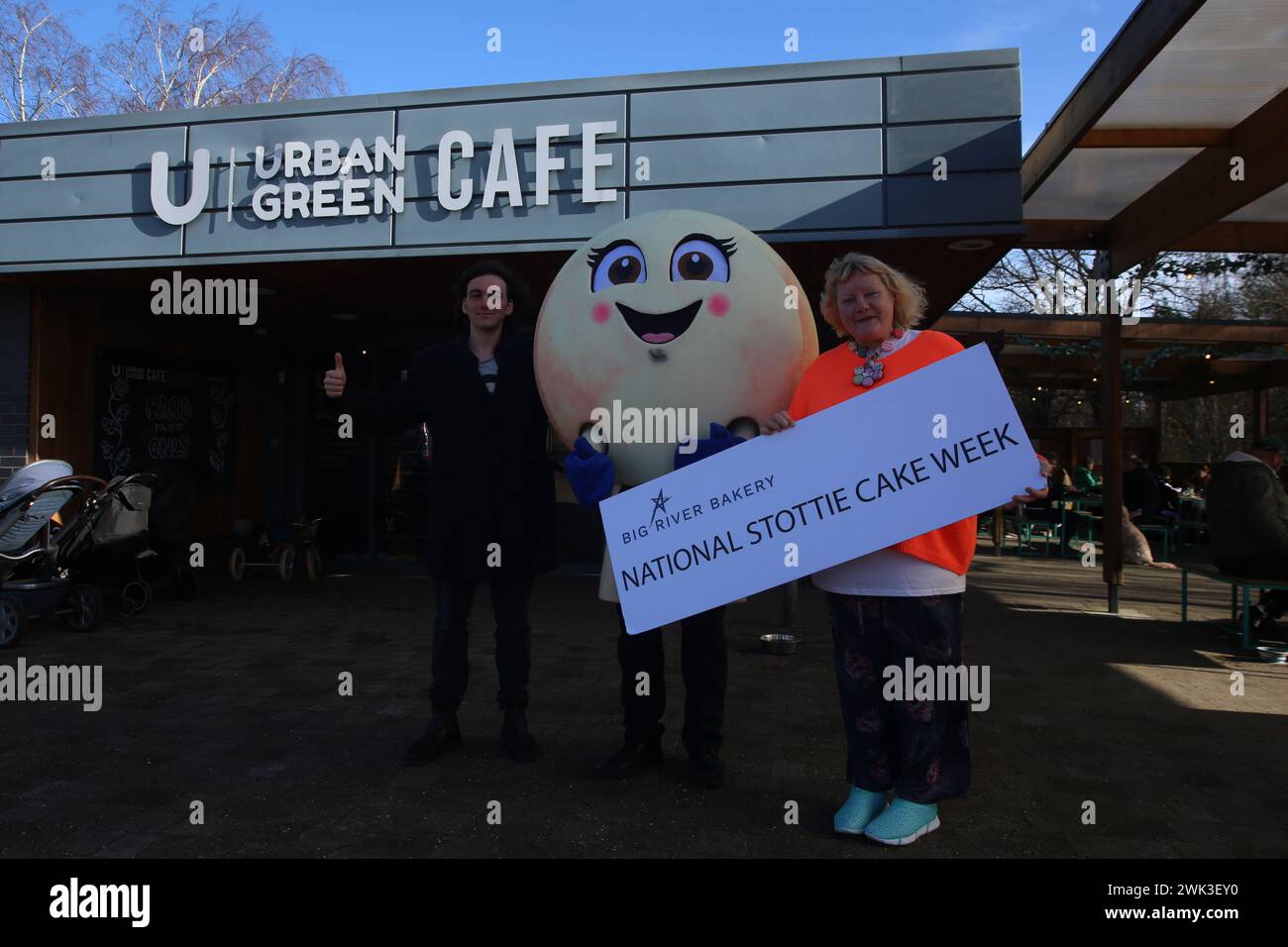 National Stottie Cake Week con la mascotte di Big River Bakery Scotty the Stottie che partecipa all'Urban Green Exhibition Park Café. La Big River Bakery, situata nel cuore di Shieldfield, Newcastle, ha recentemente annunciato una prima edizione culinaria: La National Stottie Cake Week. Una stottie è un tipo di pane rotondo, piatto e cotto sul fondo di un forno, che si traduce in una consistenza scrumptibilmente morbida ma gommosa. Prende il nome dalla parola Geordie «stot» – che significa «rimbalzare» – poiché tradizionalmente una stottie perfettamente cotta dovrebbe rimbalzare quando viene lasciata cadere. Newcastle upon Tyne, 18 febbraio 2024, credito: DEWAlamy Foto Stock