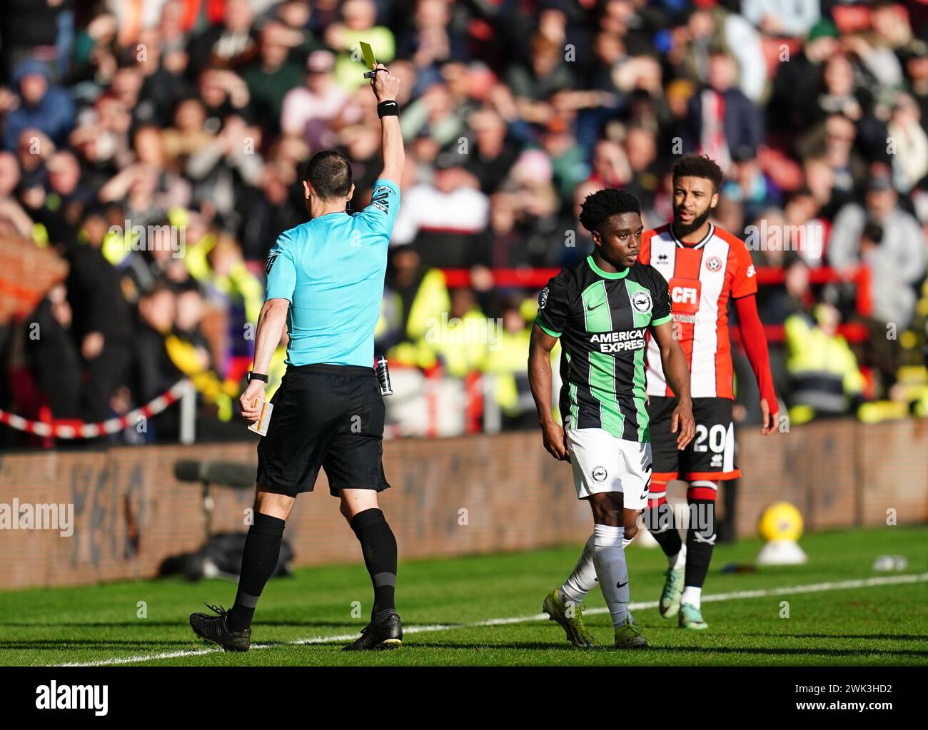 L'arbitro Stuart Attwell mostra un cartellino giallo al Tariq Lamptey di Brighton e Hove Albion durante la partita di Premier League a Bramall Lane, Sheffield. Data foto: Domenica 18 febbraio 2024. Foto Stock