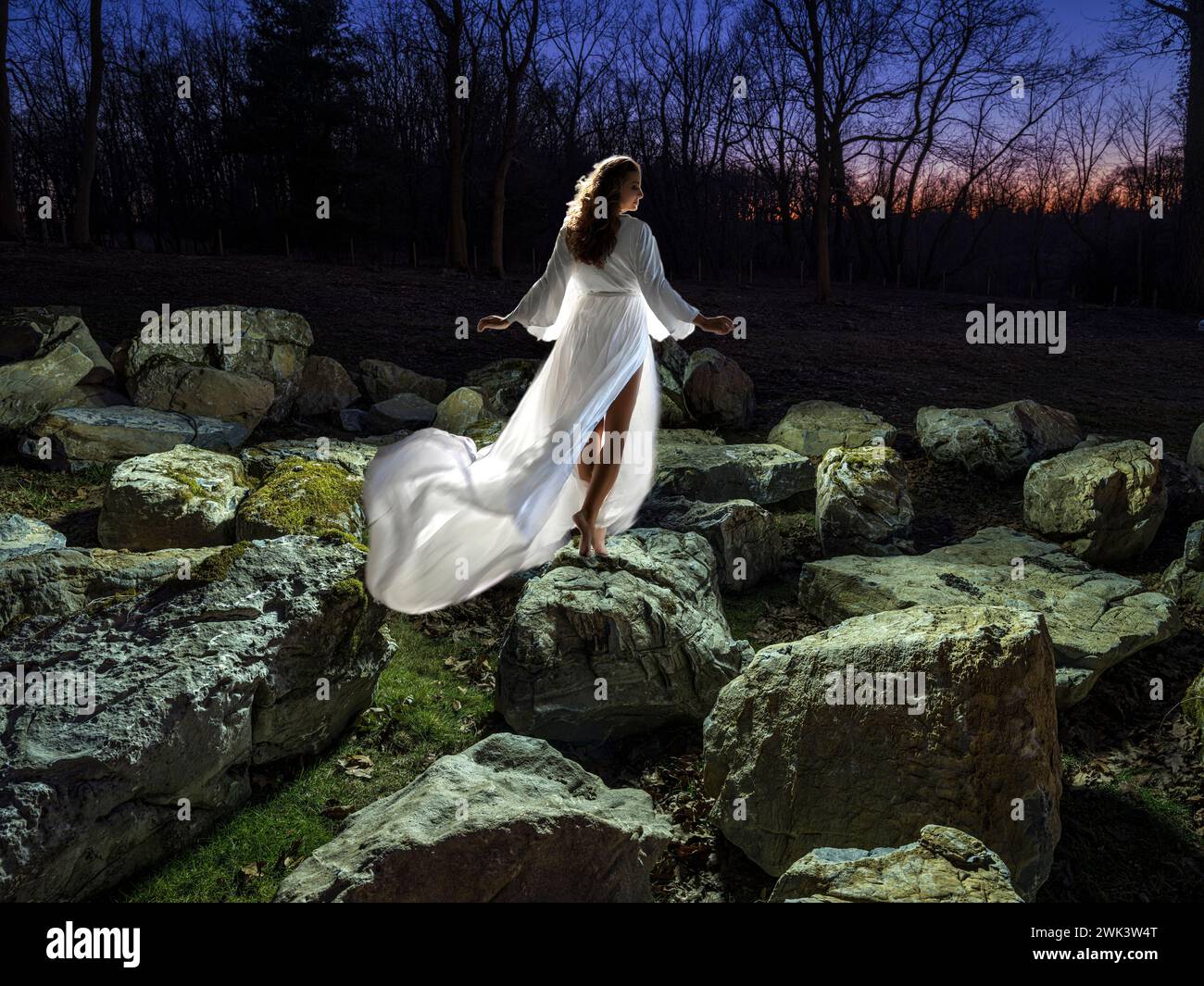 Bella donna in piedi sulle rocce in un ambiente da sogno Foto Stock