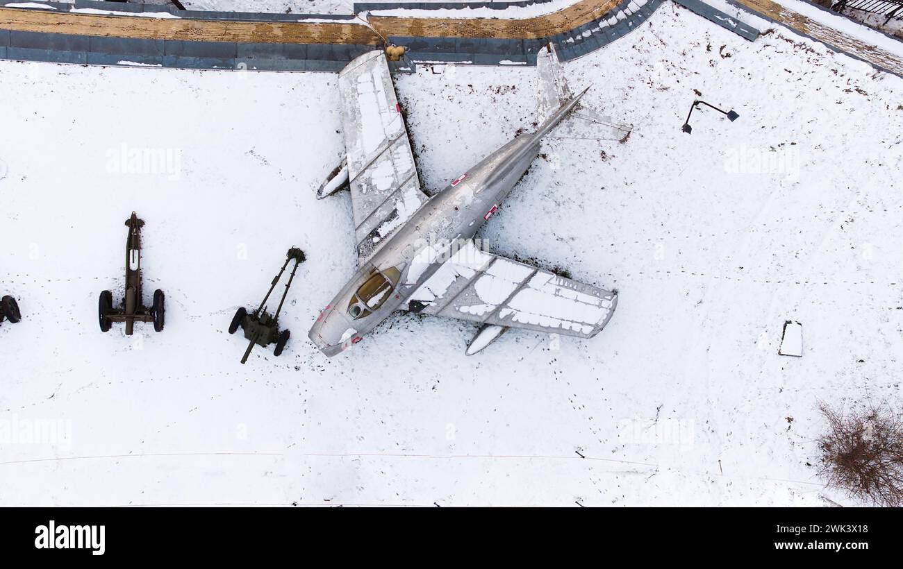 Vista aerea di carri armati ricoperti di neve, artiglieria, veicoli corazzati, veicoli militari e aeroplani nella Cittadella di Poznan durante l'inverno, fucilati da un drone. Foto Stock