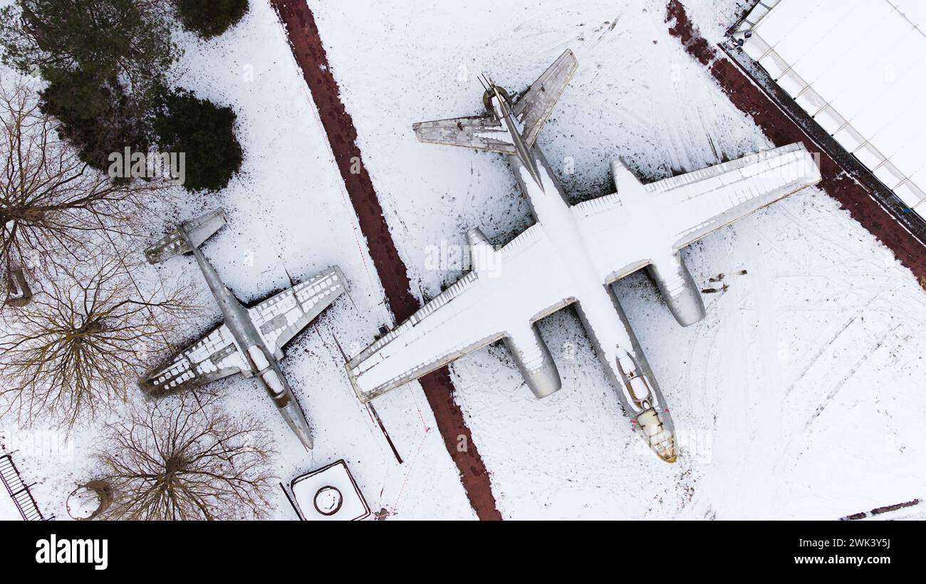 Vista aerea di carri armati ricoperti di neve, artiglieria, veicoli corazzati, veicoli militari e aeroplani nella Cittadella di Poznan durante l'inverno, fucilati da un drone. Foto Stock
