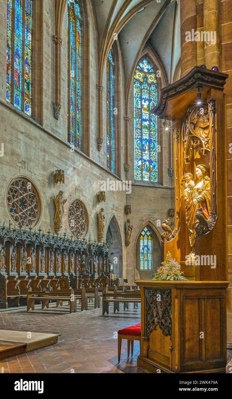 Colmar, Francia - 21 settembre 2022: Il coro di legno con una statua sacra in primo piano della chiesa di San Martin Collegiate Church Foto Stock