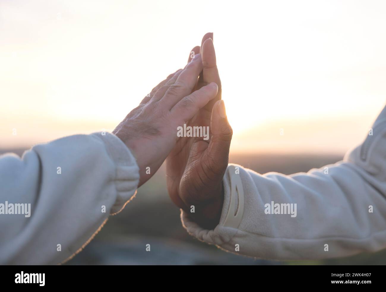 Mani di uomo bianco e afroamericano nero che si toccano dolcemente e dolcemente al tramonto. Il concetto di combattere con il razzismo e l'amicizia tra di noi Foto Stock