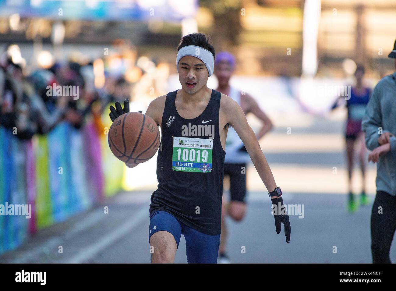 Austin, Texas, Stati Uniti. 18 febbraio 2024: Ben Duong (10019) corre con un pallacanestro fino al traguardo di 1:21:39 menÕs Division all'Austin Half Marathon. Austin, Texas. Mario Cantu/CSM. Crediti: CAL Sport Media/Alamy Live News Foto Stock