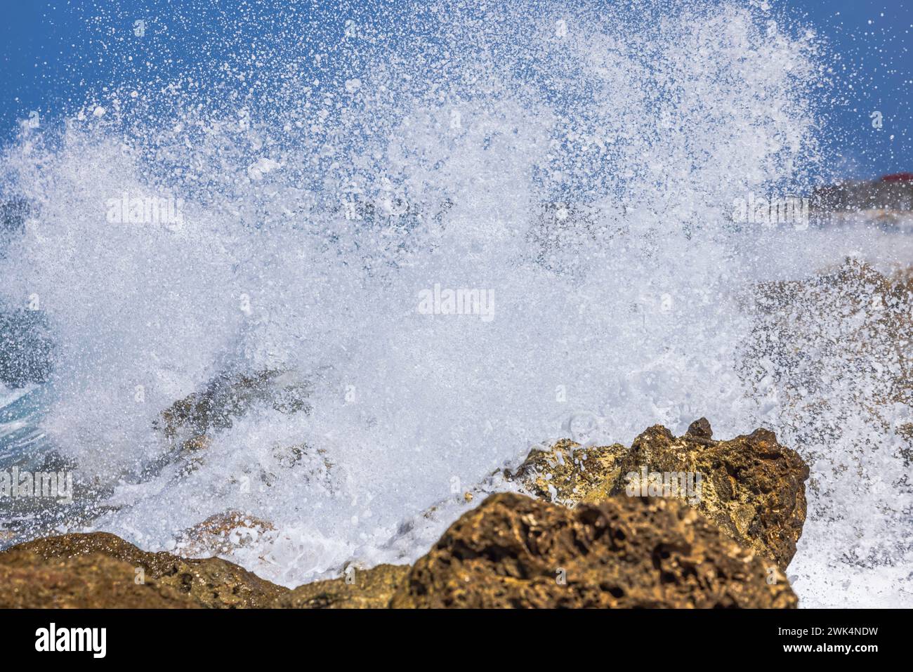 Vista ravvicinata delle onde che si schiantano contro le rocce del Mar dei Caraibi. Curacao. Foto Stock