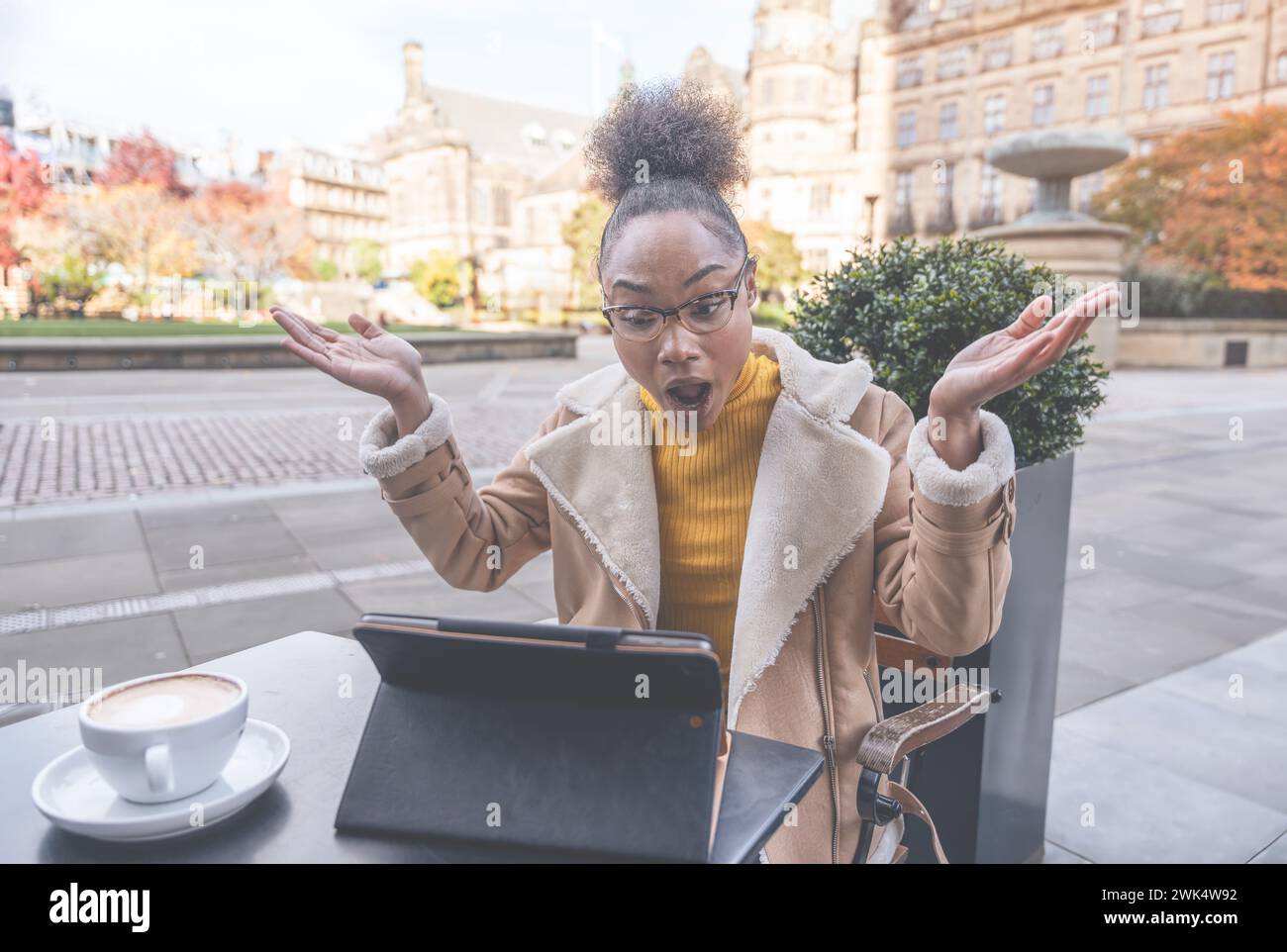 Studentessa africana e learning corso di formazione a distanza studiare lavorare in caffetteria. Giovane donna etnica che guarda il webinar online sull'istruzione utilizzando un notebook. Foto Stock