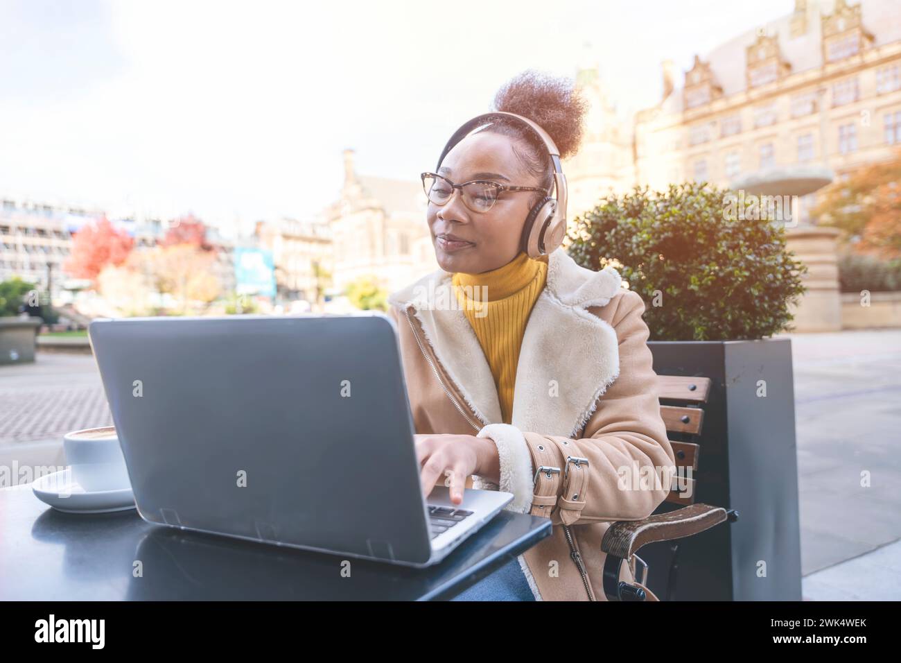 Studentessa africana e learning corso di formazione a distanza studiare lavorare in caffetteria. Giovane donna etnica che guarda il webinar online sull'istruzione utilizzando un notebook. Foto Stock