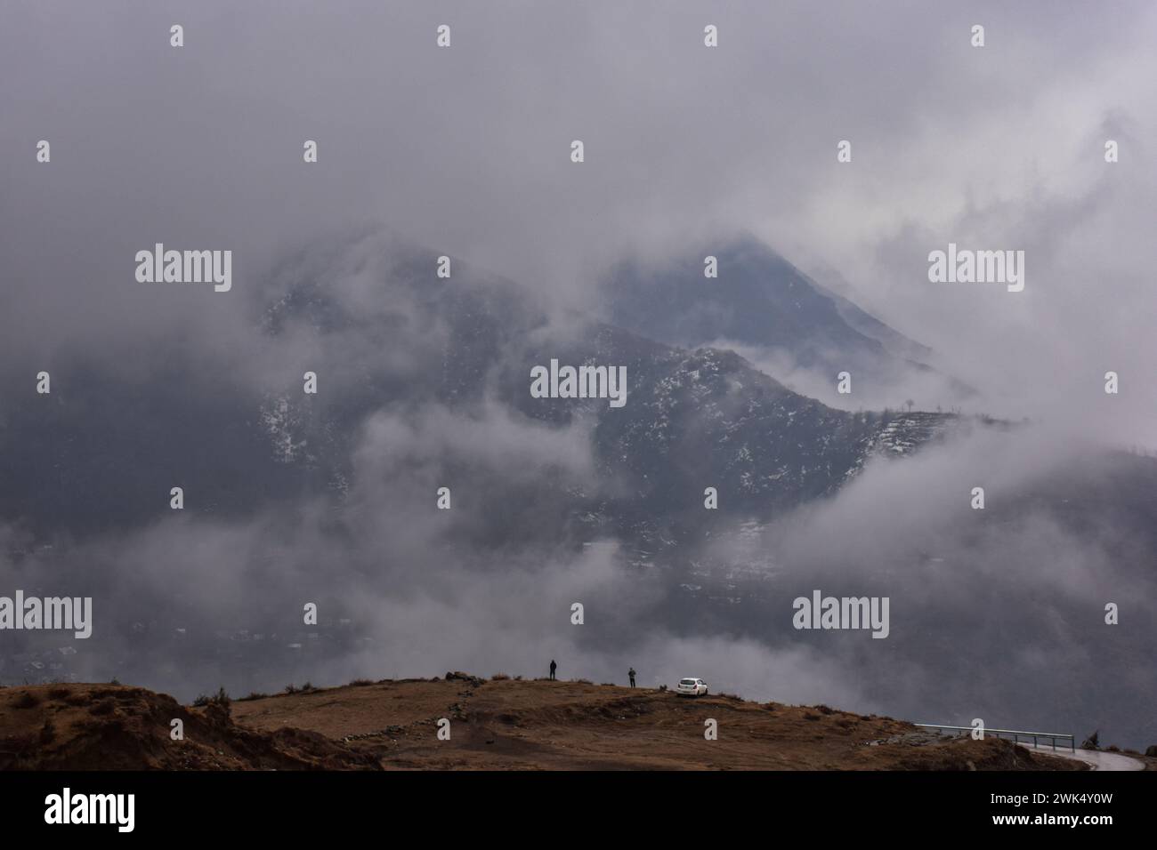 I residenti camminano lungo la collina durante la pioggia alla periferia di Srinagar, la capitale estiva di Jammu e Kashmir. Sono state segnalate nevicate fresche nei tratti più alti del Kashmir, mentre le pianure hanno subito piogge, con un conseguente calo significativo delle temperature.l'ufficio meteorologico ha previsto nevicate da moderata a pesante o precipitazioni attraverso la valle del Kashmir per i prossimi tre giorni. Foto Stock