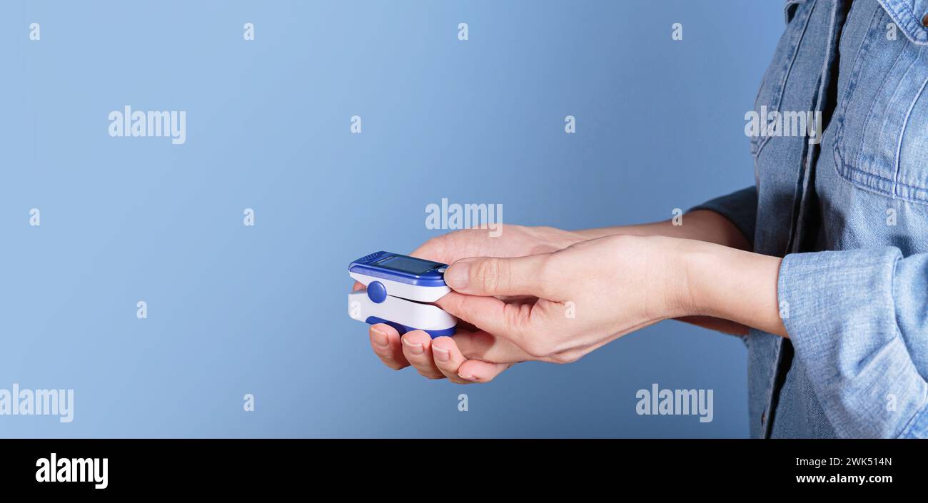 Donna che esegue l'autotest per i livelli di ossigeno nel sangue dal pulsossimetro Foto Stock